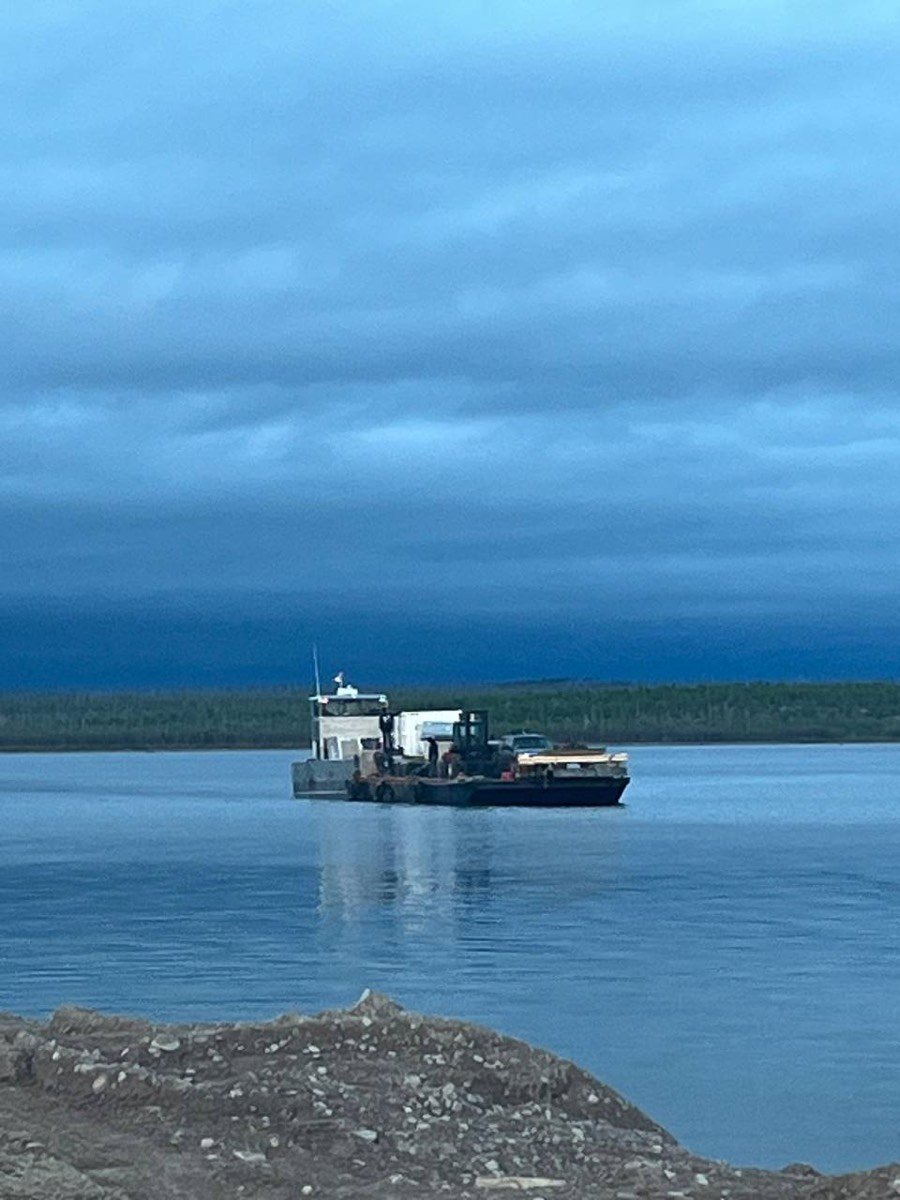 Barge loaded with equipment and a forklift at blue hour