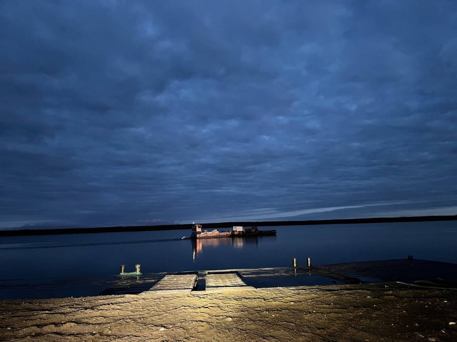 A P&M Barging vessel crossing Lake Athabasca at dusk